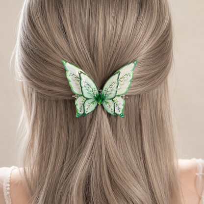 A green and white butterfly hair clip holding a low ponytail in the back of a person's head, showing long wavy light brown hair.