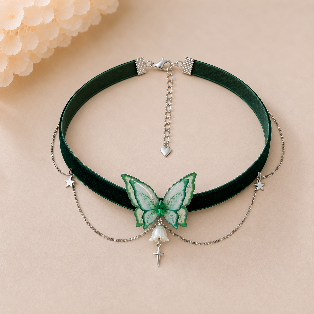 A dark green velvet choker necklace with a central green and white butterfly charm, silver chain drapes, and dangling star and bell charms, displayed on a beige background.